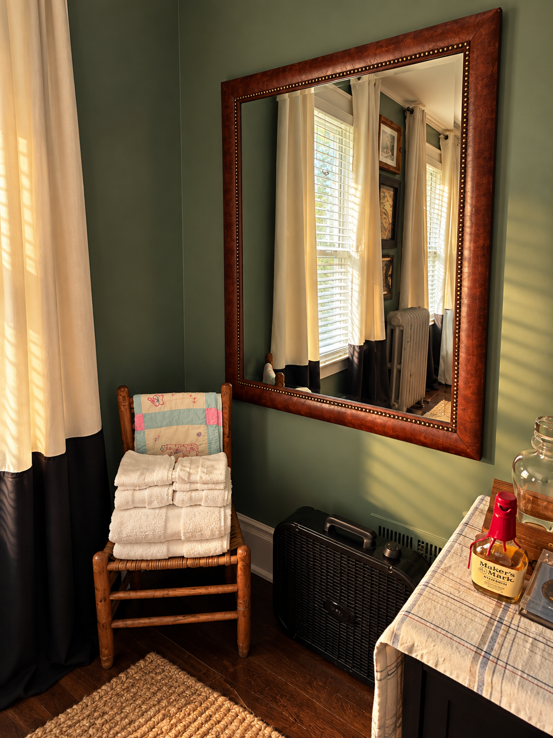 Small wooden family chair with folded towels and Steve's baby blanket beside a large framed mirror