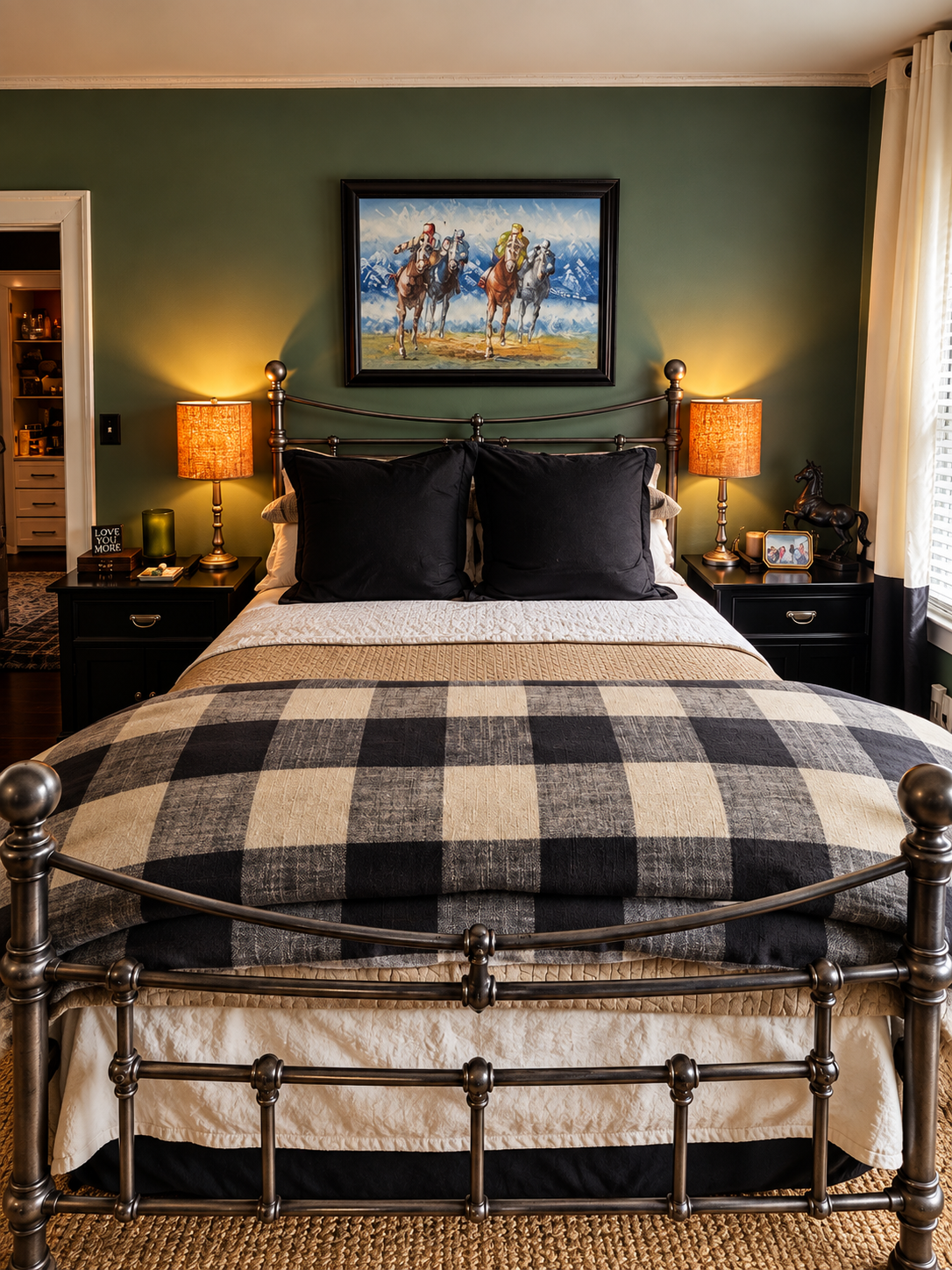 The Kentucky guest room with green walls, iron bed, black-and-white bedding, and warm bedside lamps