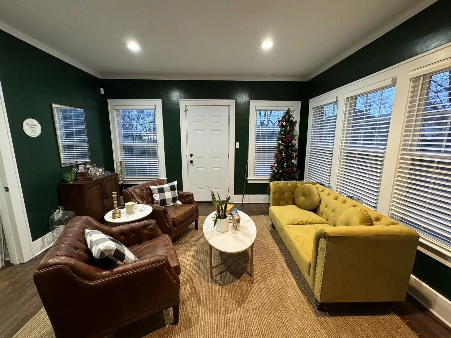 Early version of the green library with leather chairs and mustard sofa