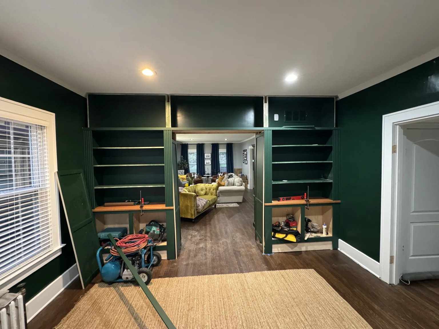 Library built-ins with fluted trim and upper bridge taking shape around the passage