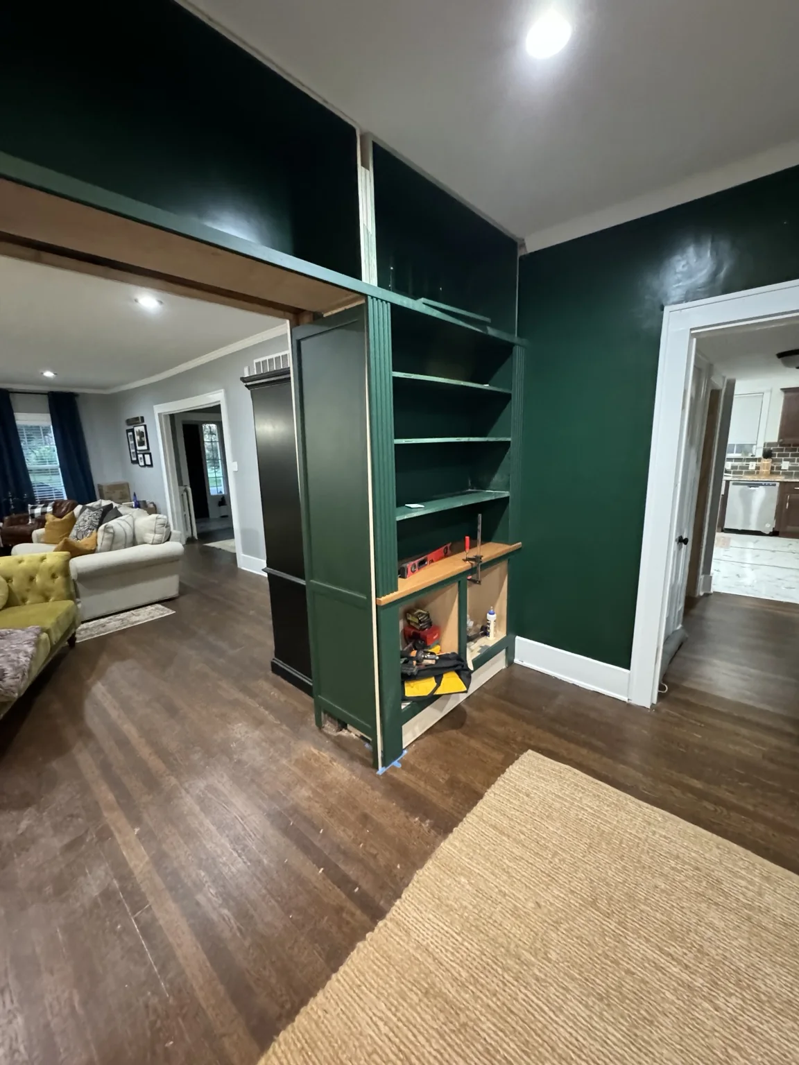 Angled view of the green built-ins during installation showing their depth around the passage