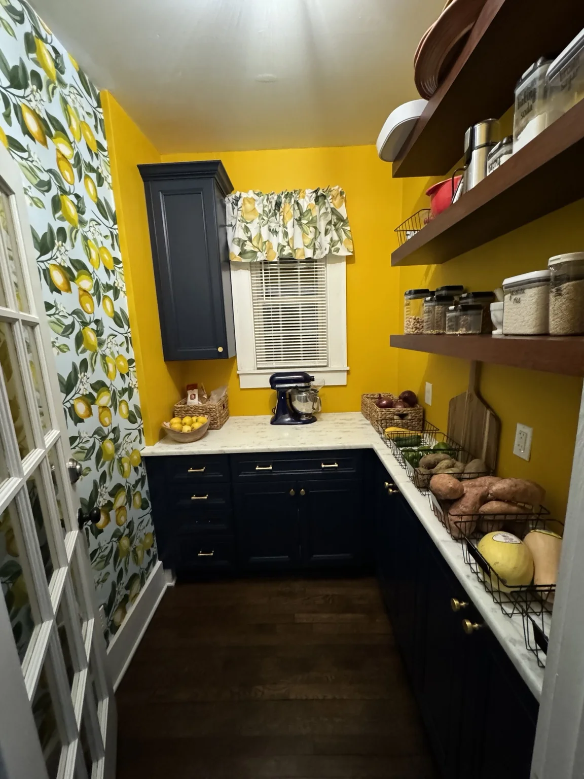 Finished pantry at The Meeks House with yellow walls and dark cabinetry