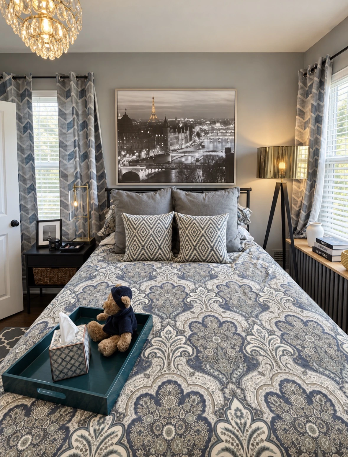 Front view of the bed beneath Paris artwork, flanked by brass lamps