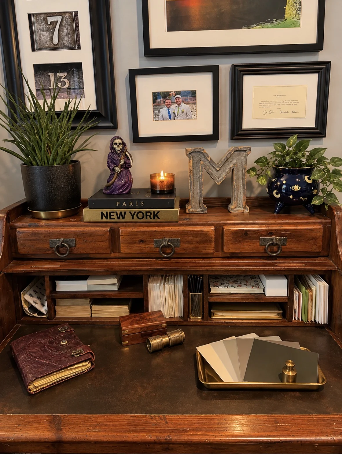 Writing desk vignette with framed wall art, candle, and small seasonal accents