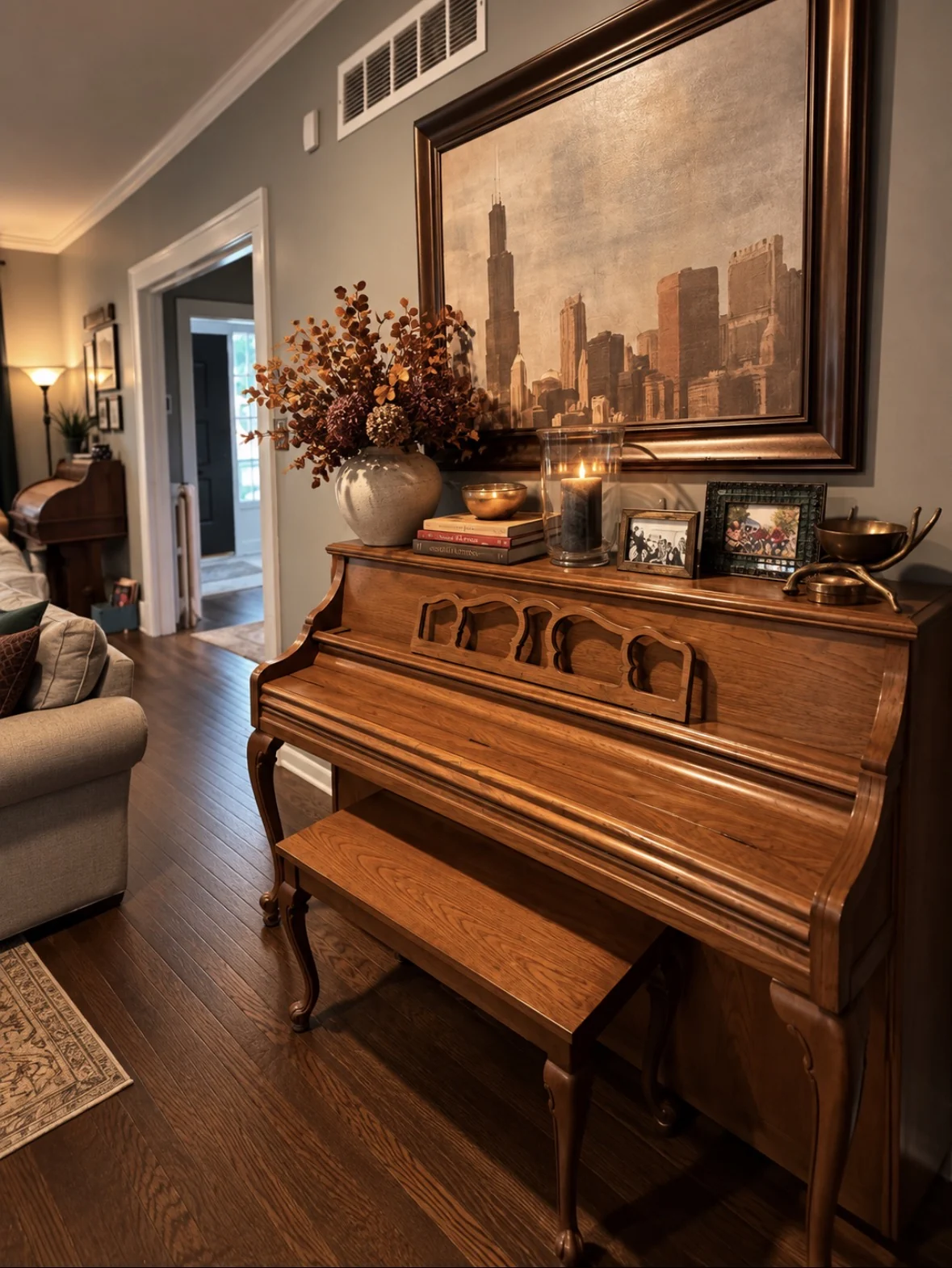Piano styled for fall with artwork, candlelight, and warm-toned florals
